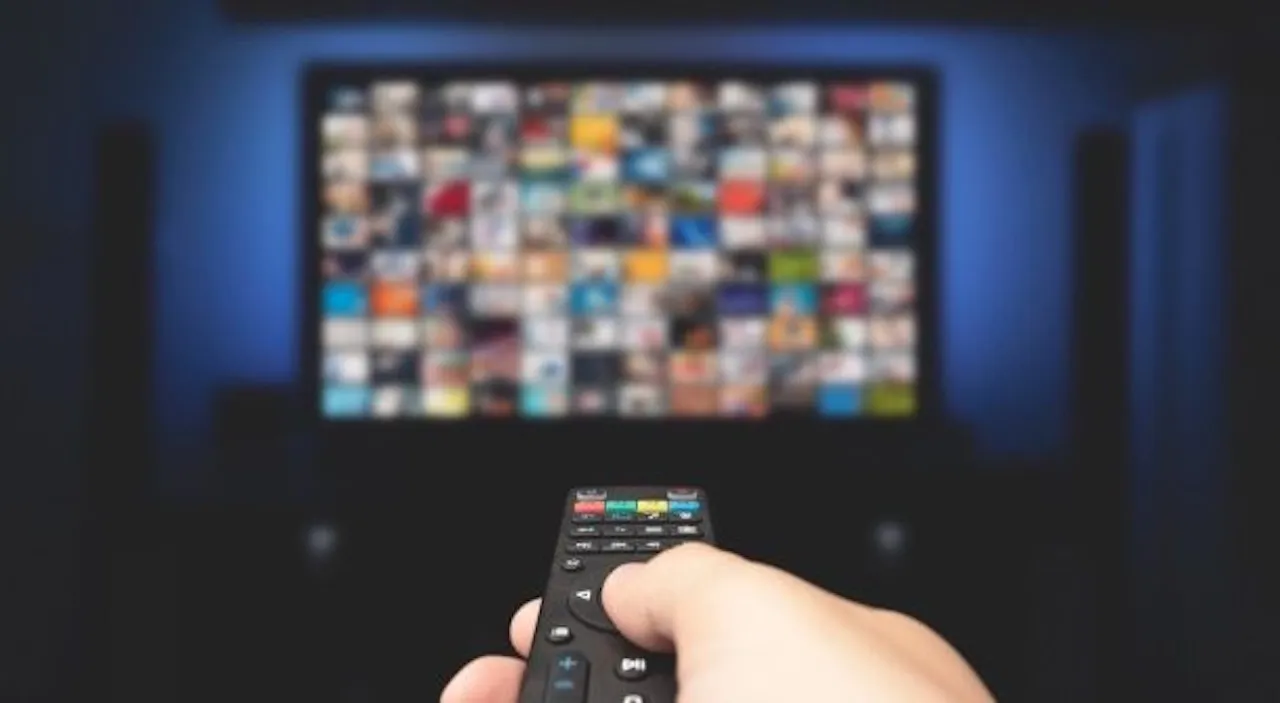 Daimon Energy - Tv-Anlage - eine Person, die die Fernbedienung eines Smart-TVs verwendet